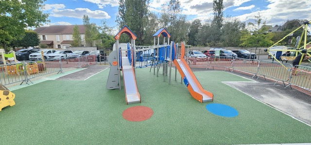 Cour d'école aménagée avec aire de jeux et sol amortissant vert et bleu