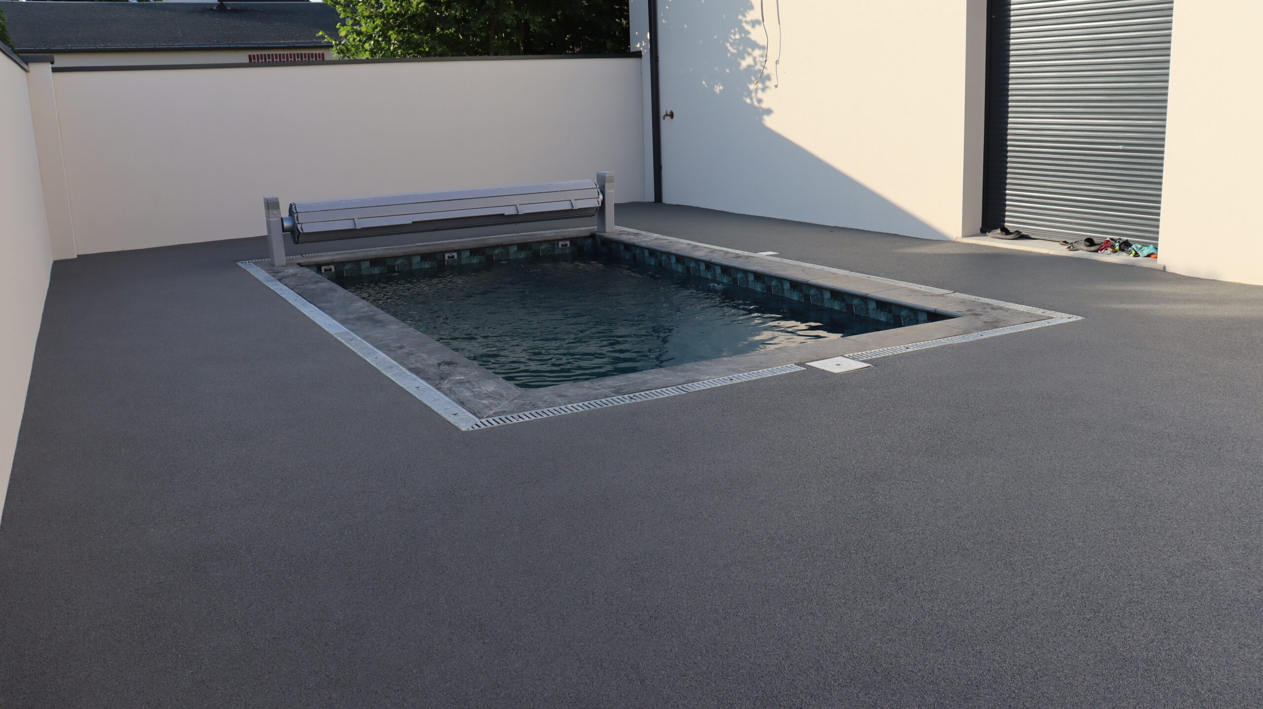 Revêtement extérieur souple gris autour d'une piscine